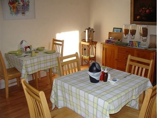 Breakfast room with checkered tablecloths and sideboard
