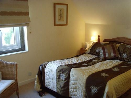 Double guest room with patterned bedding and cane chair