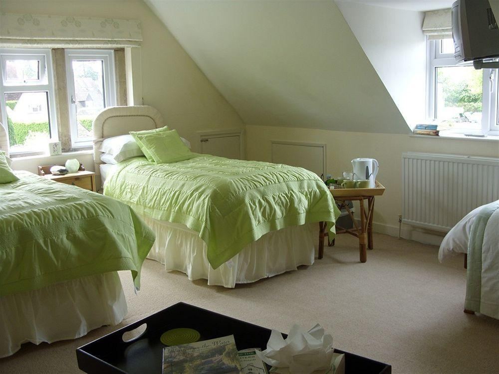 Twin guest room with green bedding, tea tray and TV